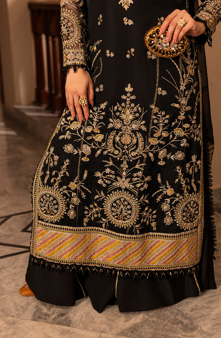 Black embroidered traditional outfit with gold details on a neutral background
