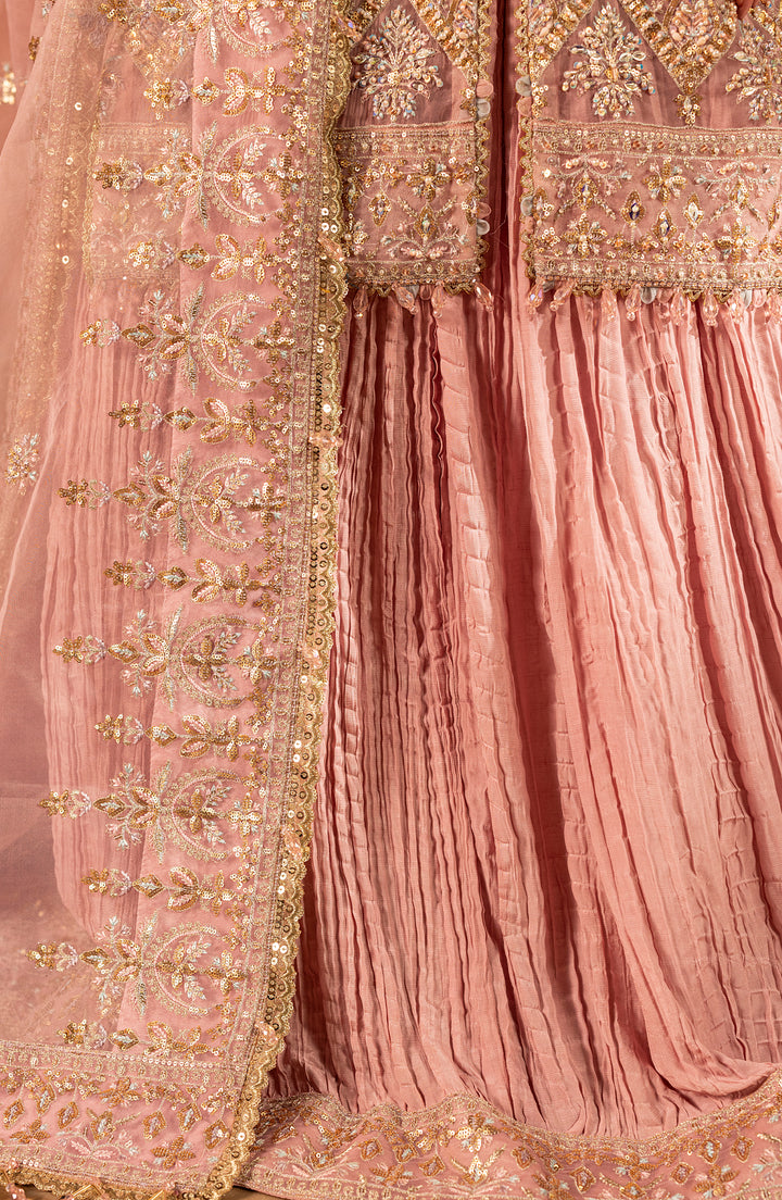 Close-up of a pink traditional outfit with gold embroidery