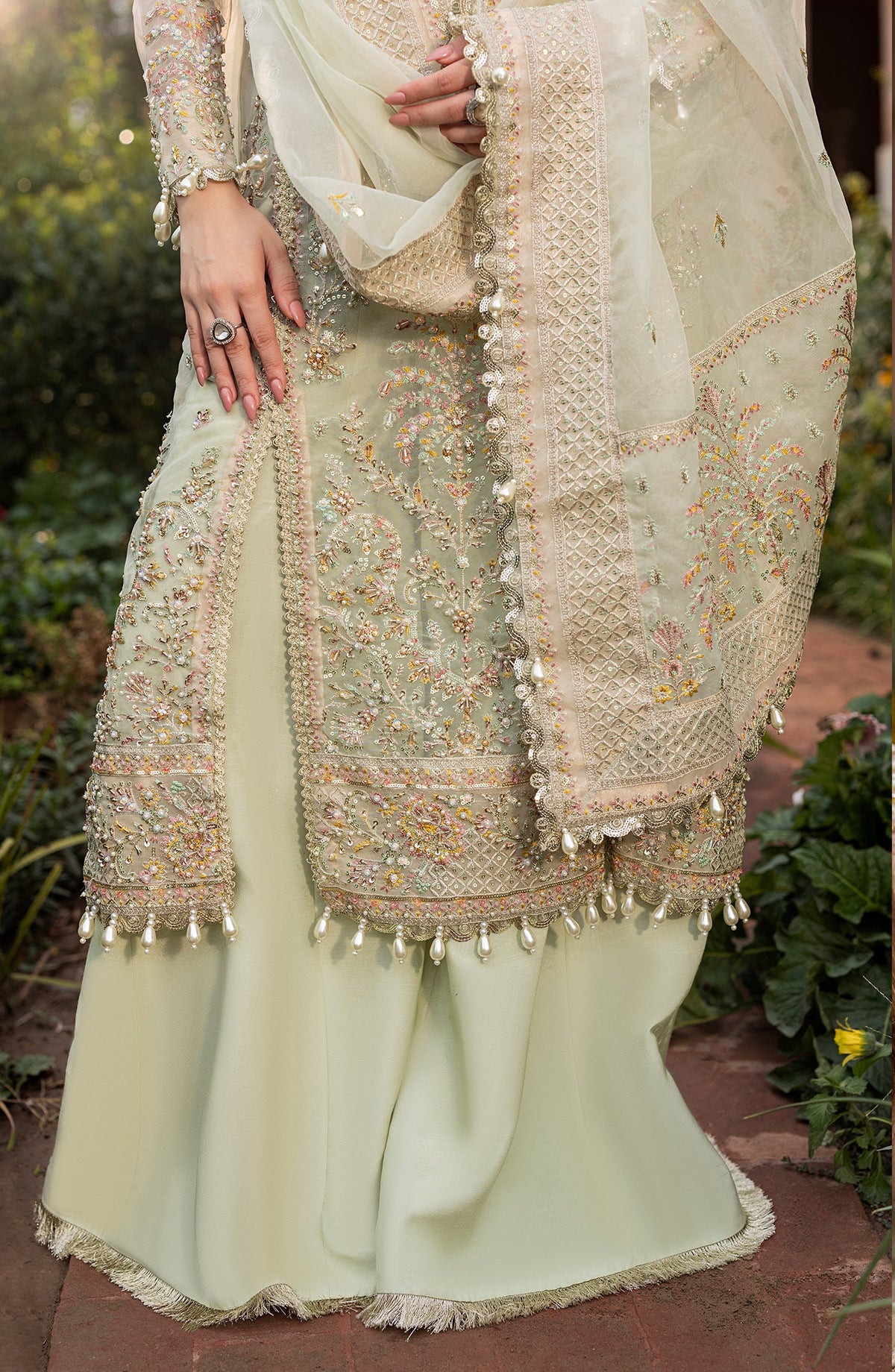 Traditional outfit with intricate embroidery and embellishments in a natural setting.
